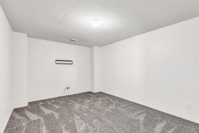 unfurnished room with carpet and a textured ceiling