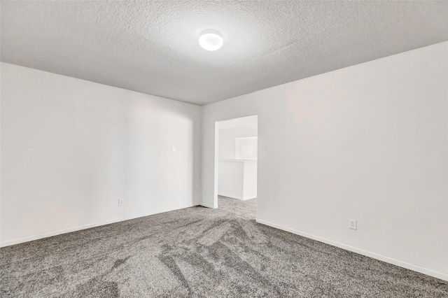 carpeted empty room with a textured ceiling