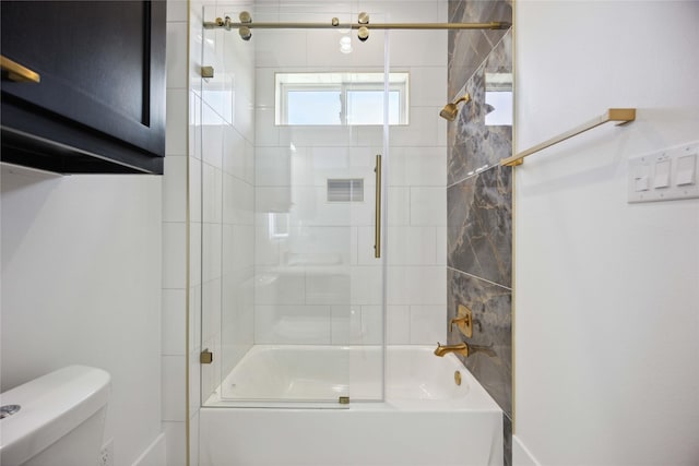 bathroom featuring enclosed tub / shower combo and toilet