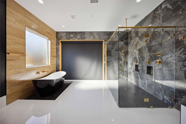 bathroom featuring tile patterned floors, plus walk in shower, and tile walls