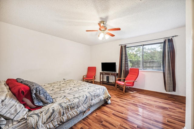 bedroom featuring hardwood / wood-style flooring, ceiling fan, and a textured ceiling