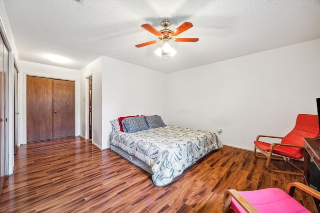 bedroom featuring dark hardwood / wood-style floors, ceiling fan, a textured ceiling, and a closet