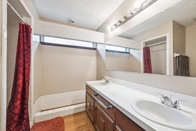 bathroom featuring vanity, a textured ceiling, hardwood / wood-style flooring, and walk in shower