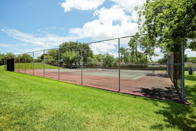 view of sport court with a lawn