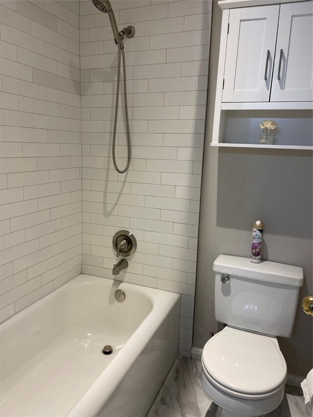 bathroom with tiled shower / bath combo and toilet