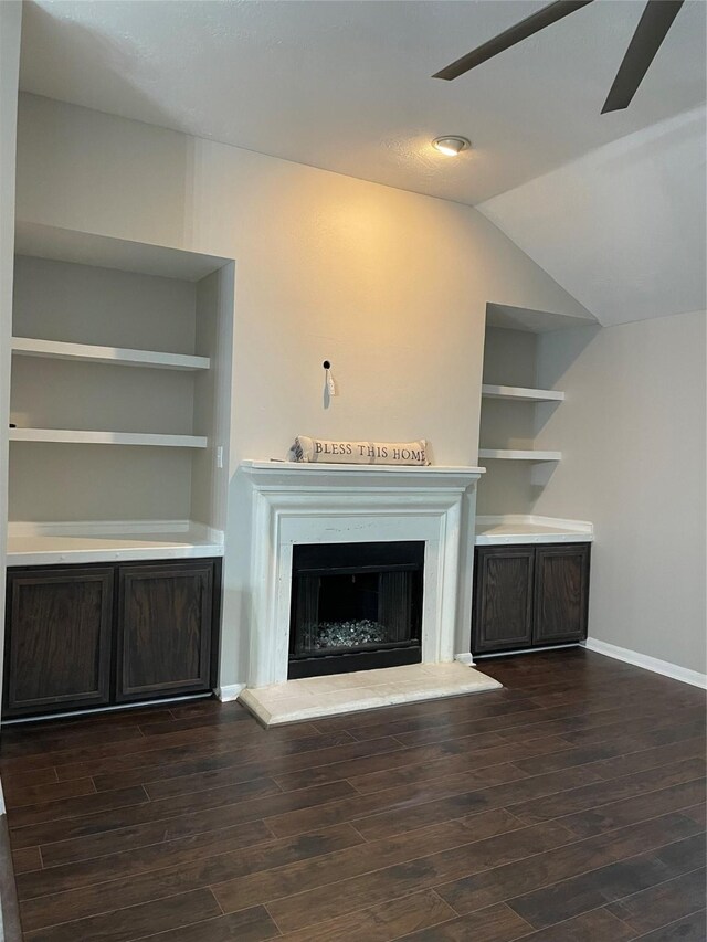 unfurnished living room featuring vaulted ceiling, dark hardwood / wood-style floors, and ceiling fan