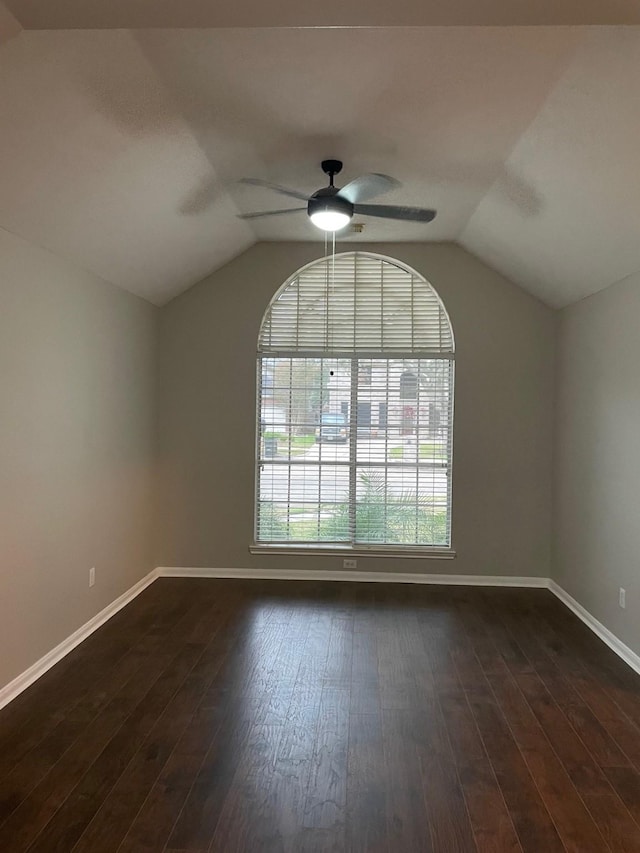 empty room with dark wood-type flooring, ceiling fan, and lofted ceiling