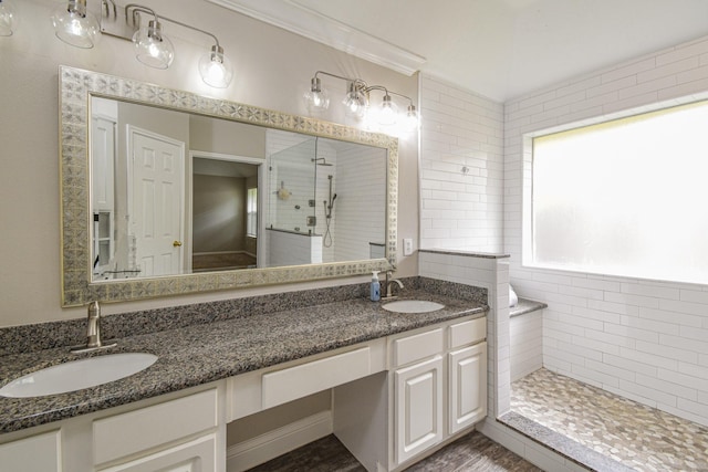 bathroom featuring vanity, tiled shower, and crown molding