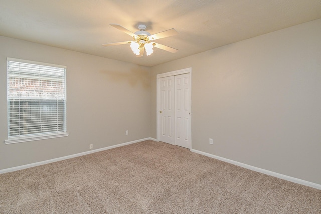 empty room with ceiling fan and carpet flooring