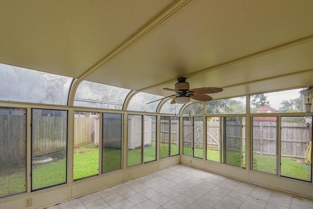 unfurnished sunroom featuring ceiling fan and a healthy amount of sunlight