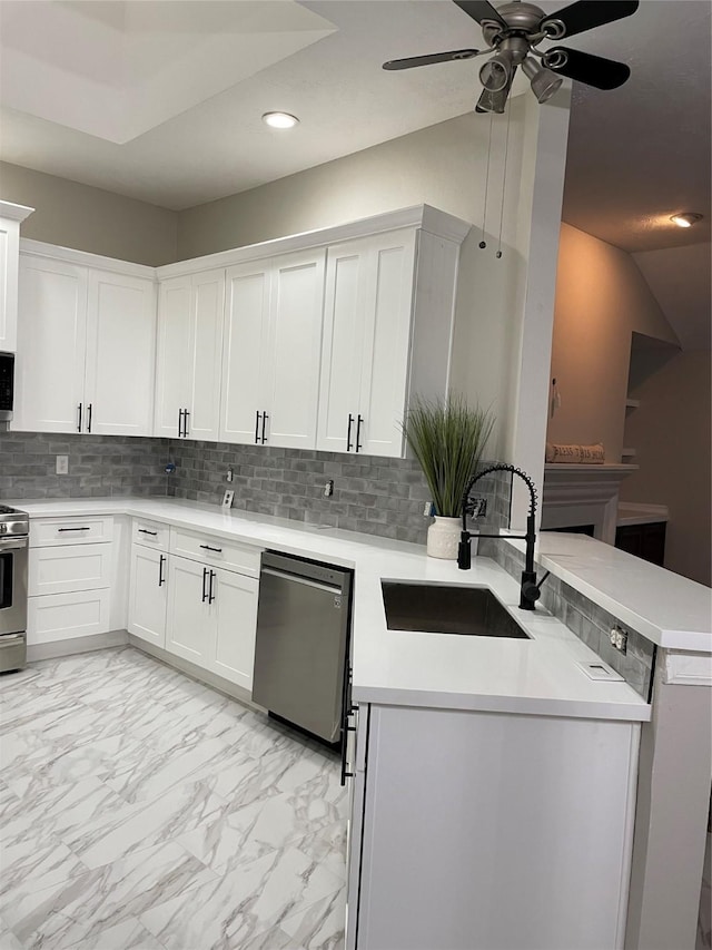 kitchen featuring sink, appliances with stainless steel finishes, white cabinets, decorative backsplash, and kitchen peninsula