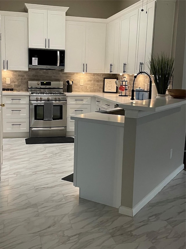 kitchen with marble finish floor, stainless steel appliances, light countertops, and white cabinets