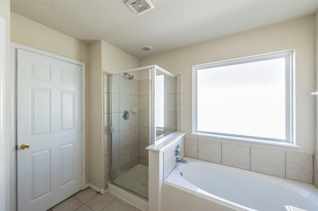 bathroom with tile patterned flooring, a textured ceiling, and separate shower and tub