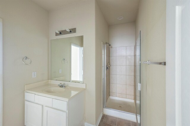 bathroom with tile patterned floors, vanity, and a shower with door