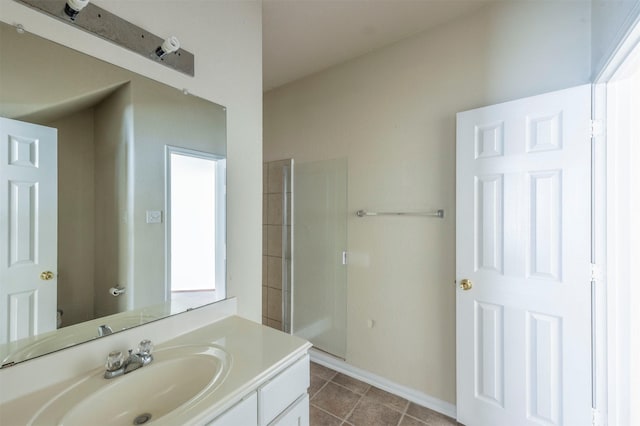 bathroom featuring tile patterned flooring, vanity, and tiled shower