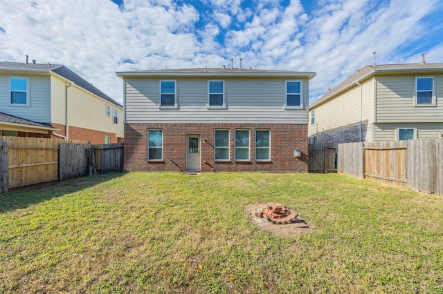 back of property featuring a lawn and an outdoor fire pit