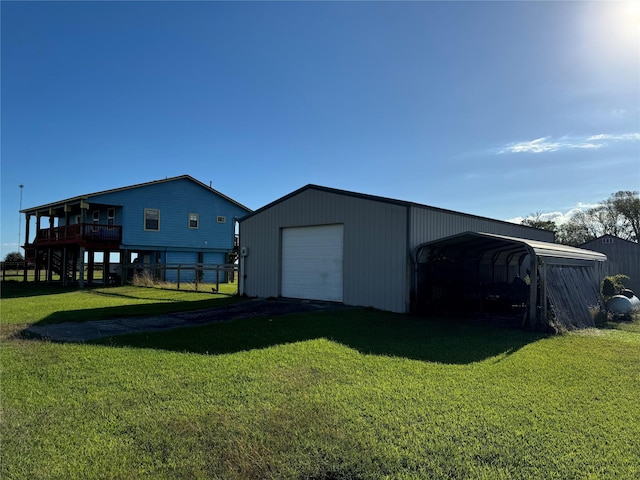 exterior space featuring a lawn, a carport, a wooden deck, a garage, and an outdoor structure