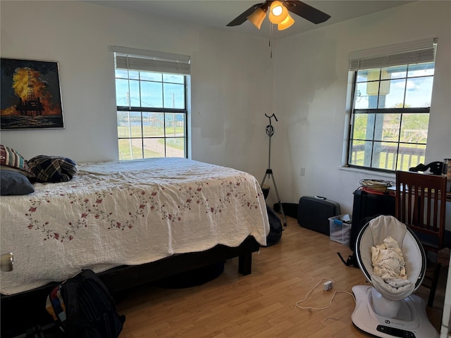 bedroom featuring hardwood / wood-style flooring, multiple windows, and ceiling fan