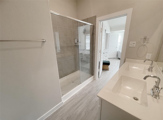 bathroom with wood-type flooring, vanity, and walk in shower