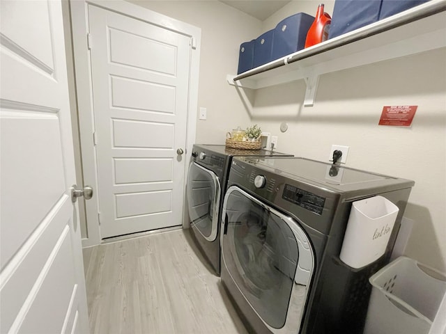 washroom featuring washing machine and dryer and light hardwood / wood-style floors