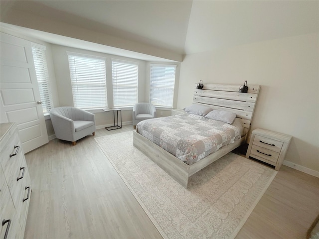 bedroom featuring light hardwood / wood-style floors and vaulted ceiling