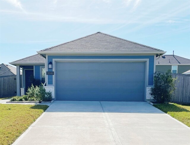 ranch-style home featuring a front yard and a garage