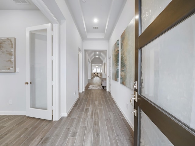 corridor with french doors and light hardwood / wood-style floors