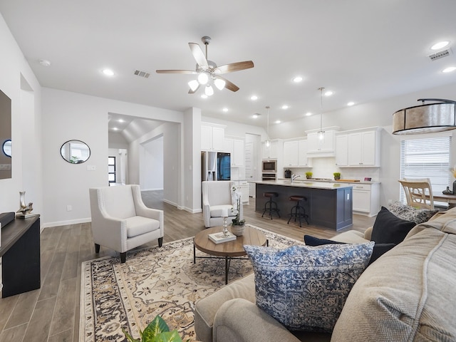 living room with ceiling fan and light hardwood / wood-style flooring