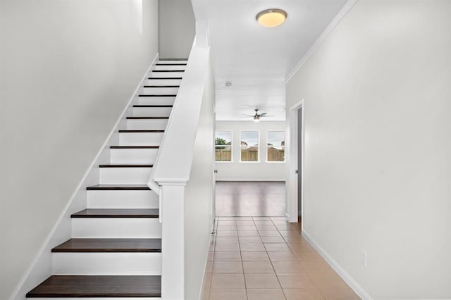 staircase with tile patterned floors, ceiling fan, and ornamental molding