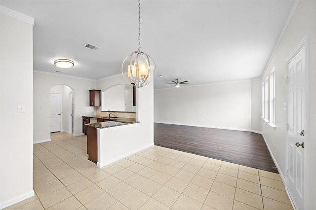 kitchen featuring sink, hanging light fixtures, light hardwood / wood-style flooring, kitchen peninsula, and ceiling fan with notable chandelier