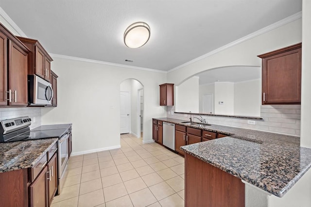 kitchen with dark stone countertops, backsplash, and appliances with stainless steel finishes