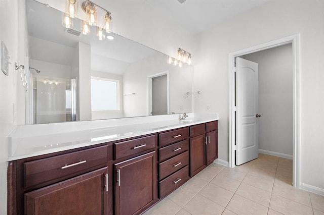 bathroom with tile patterned flooring, vanity, and walk in shower