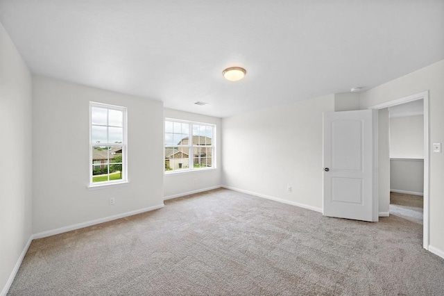 spare room featuring light colored carpet