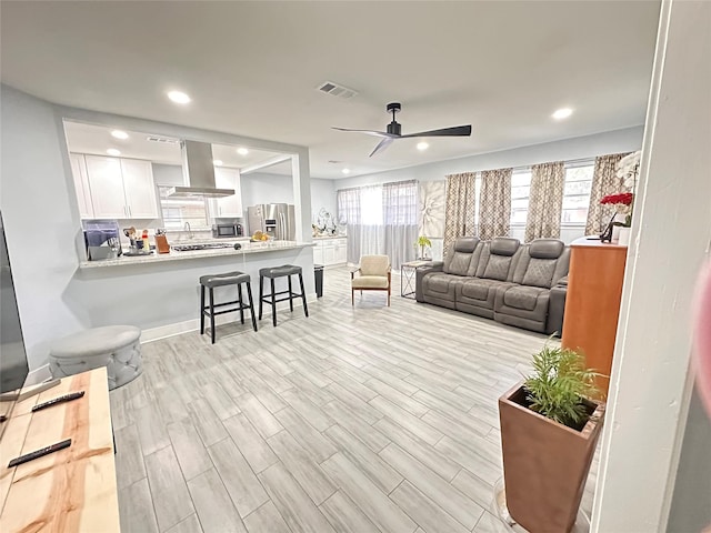 living room featuring ceiling fan and light wood-type flooring