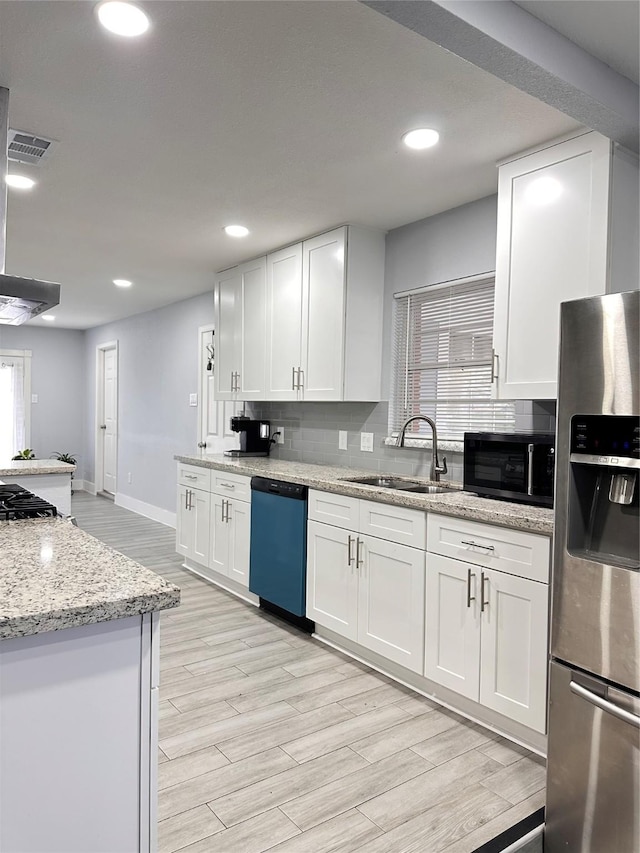 kitchen with a wealth of natural light, sink, white cabinets, and stainless steel appliances