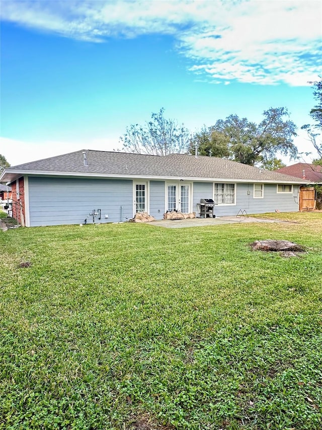 rear view of property with a lawn and a patio