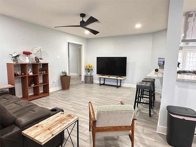 living room featuring light hardwood / wood-style floors and ceiling fan