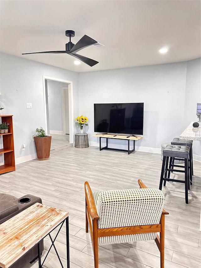 living room with ceiling fan and light hardwood / wood-style flooring