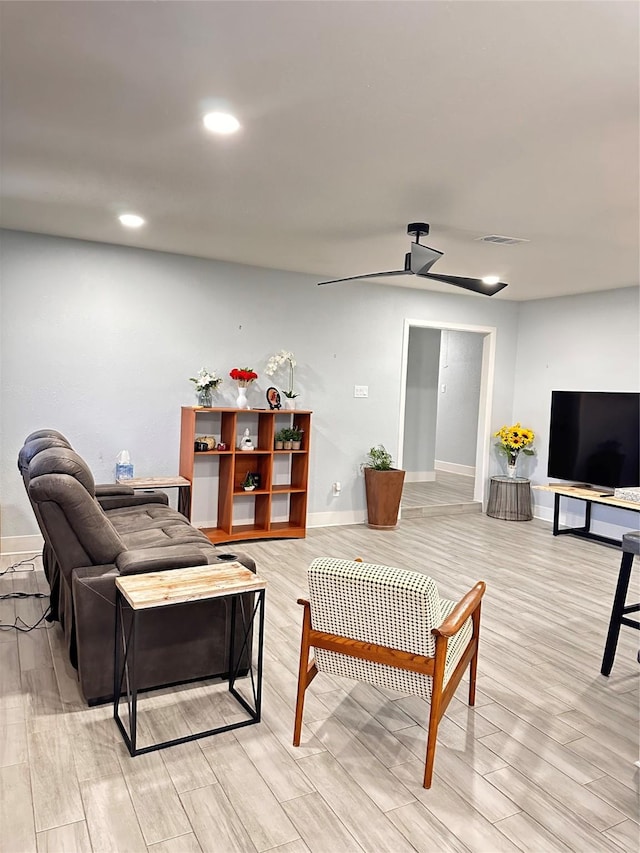 living room featuring ceiling fan and light wood-type flooring