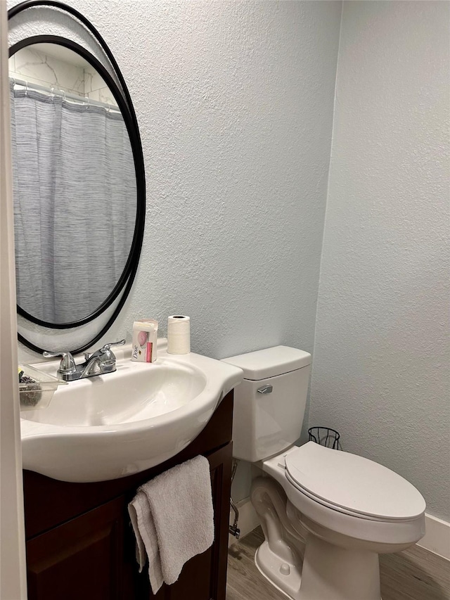 bathroom featuring hardwood / wood-style floors, vanity, and toilet