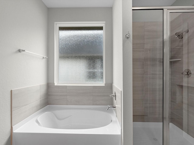 bathroom featuring plus walk in shower and a wealth of natural light