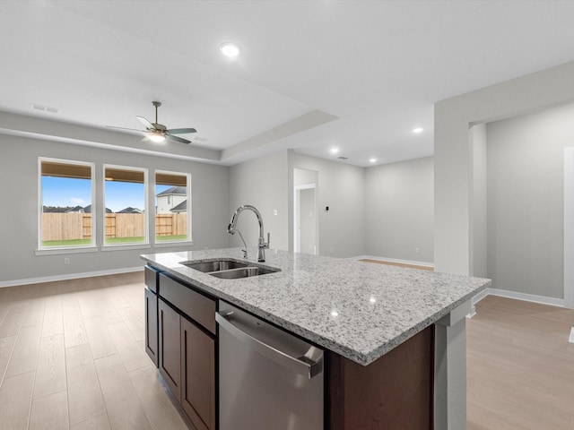 kitchen featuring light wood-type flooring, sink, stainless steel dishwasher, dark brown cabinets, and light stone counters