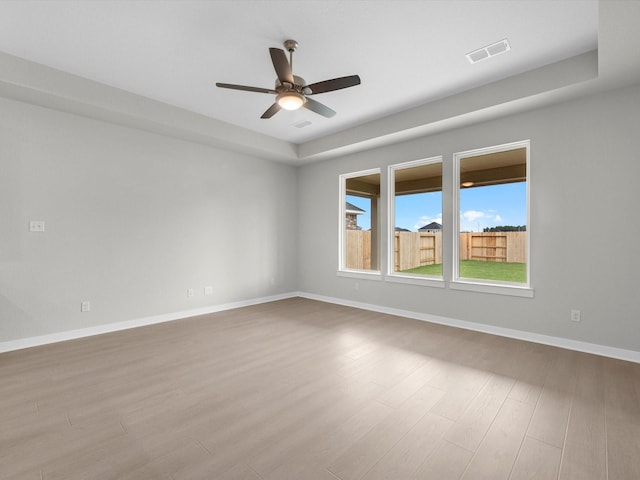 empty room with ceiling fan and light hardwood / wood-style flooring