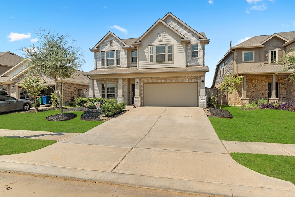 craftsman house with a front yard and a garage