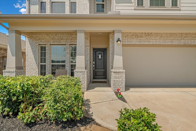 doorway to property with covered porch and a garage