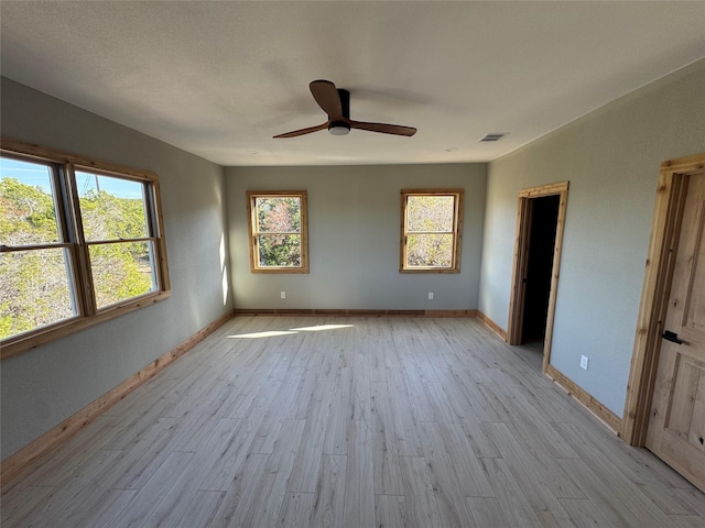 unfurnished bedroom featuring a spacious closet, ceiling fan, and light hardwood / wood-style flooring