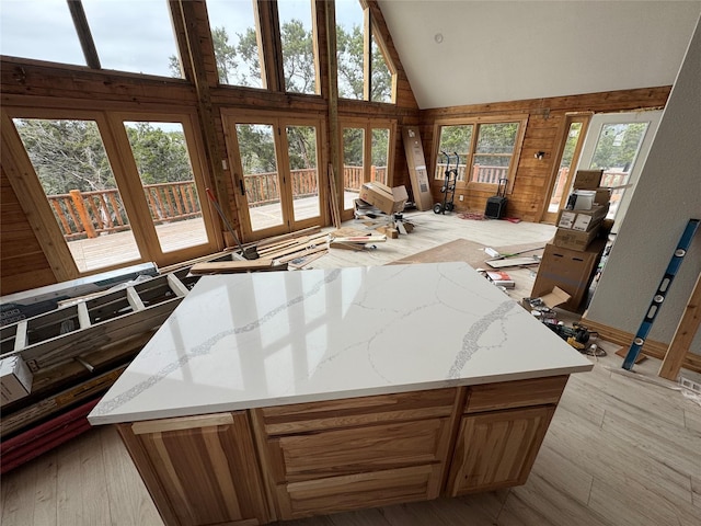 kitchen with a high ceiling, light stone countertops, and light wood-type flooring