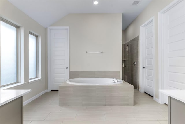 bathroom with tile patterned floors, vanity, separate shower and tub, and lofted ceiling