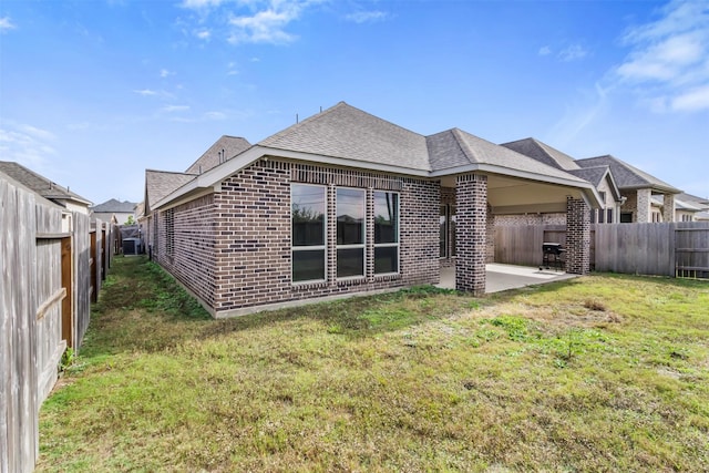 rear view of property featuring a yard and a patio