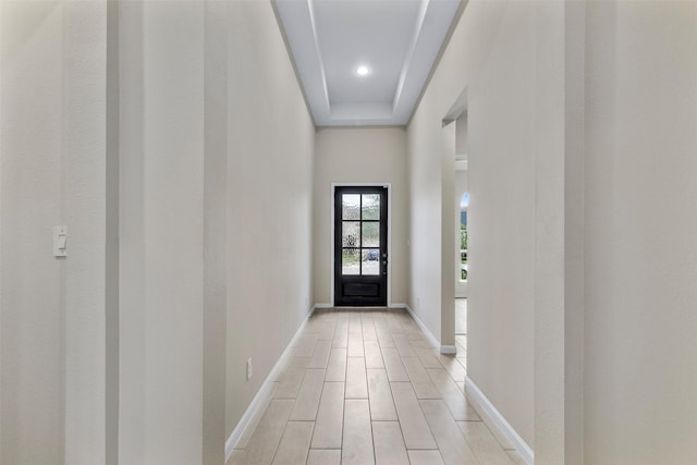 entryway with light hardwood / wood-style floors and a tray ceiling